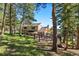 Charming exterior view of home with a multi-level deck, surrounded by lush trees and landscaping at 929 Coneflower Dr, Golden, CO 80401