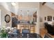 Open concept kitchen with natural wood cabinets, black countertops, stainless steel appliances, and bar seating at 929 Coneflower Dr, Golden, CO 80401