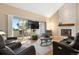 Comfortable living room featuring a stone fireplace, vaulted ceiling, leather seating, and access to a balcony at 929 Coneflower Dr, Golden, CO 80401