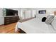 Bedroom with a plush bed, dresser with television, hardwood floors, and bright natural light at 929 Coneflower Dr, Golden, CO 80401