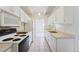 Efficient galley kitchen with modern white appliances and cabinetry, and tiled floor at 7865 E Mississippi Ave # 1502, Denver, CO 80247