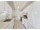 Bright kitchen with white cabinetry, modern appliances, neutral countertops, and tiled floor at 7865 E Mississippi Ave # 1502, Denver, CO 80247