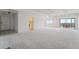 Expansive living room with white walls and light carpet, showcasing access to the kitchen and balcony at 7865 E Mississippi Ave # 1502, Denver, CO 80247