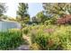 Scenic backyard garden with a stone path, flowers, and garden beds with a shed and a white fence at 8888 W 37Th Pl, Wheat Ridge, CO 80033