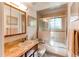 Traditional bathroom with single sink vanity, tub/shower and decorative wallpaper at 8888 W 37Th Pl, Wheat Ridge, CO 80033