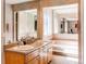 Bright bathroom featuring a dual sink vanity, large mirrors and a separate soaking tub at 8888 W 37Th Pl, Wheat Ridge, CO 80033