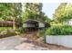 Exterior shot of a carport surrounded by lush greenery and an adjacent concrete pad at 8888 W 37Th Pl, Wheat Ridge, CO 80033