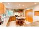 Open kitchen with stainless hood, center island with seating, and light tile flooring at 8888 W 37Th Pl, Wheat Ridge, CO 80033