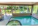 Indoor pool and spa surrounded by large windows with backyard views at 8888 W 37Th Pl, Wheat Ridge, CO 80033