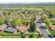 An aerial view shows a home nestled in a beautiful neighborhood surrounded by lush greenery and mature trees at 9099 W Harvard Pl, Lakewood, CO 80227