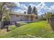 Charming backyard with a covered patio, green lawn, and wooden fence at 9099 W Harvard Pl, Lakewood, CO 80227