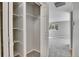 Bedroom walk-in closet with white shelving and the carpeted bedroom visible through the open door at 9099 W Harvard Pl, Lakewood, CO 80227
