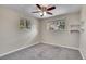 Sunlit bedroom with gray carpet, neutral walls, and a ceiling fan at 9099 W Harvard Pl, Lakewood, CO 80227
