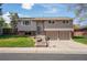 Charming two-story home with a manicured lawn, beautiful terraced garden, and an attached two-car garage at 9099 W Harvard Pl, Lakewood, CO 80227