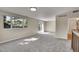Spacious living area with new carpet, neutral paint, large window, and a sliding glass door to the back yard at 9099 W Harvard Pl, Lakewood, CO 80227