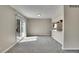 Spacious living area with new carpet, neutral paint, and a sliding glass door to the back yard at 9099 W Harvard Pl, Lakewood, CO 80227