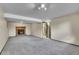 Carpeted living room showcasing a cozy brick fireplace, neutral walls, and bright ceiling lights at 9099 W Harvard Pl, Lakewood, CO 80227