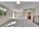 Spacious living area with new carpet, neutral paint, large window, and a sliding glass door to the back yard at 9099 W Harvard Pl, Lakewood, CO 80227