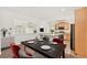 Dining area with a black table and red chairs near the kitchen at 4849 Halifax Ct, Denver, CO 80249