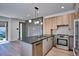 Modern kitchen boasts gray island, wooden cabinets, stainless appliances, and stylish pendant lighting at 1823 Grove St, Denver, CO 80204