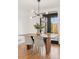 The stylish dining area features a modern chandelier, black-framed doors, and views of the backyard at 3440 N Harrison St, Denver, CO 80205
