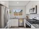This modern kitchen features stainless appliances, white subway tile, black countertops, and a bright window at 3440 N Harrison St, Denver, CO 80205