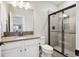 Modern bathroom with a glass-enclosed shower, neutral tile, contemporary fixtures, and a stylish vanity at 8621 S De Gaulle Ct, Aurora, CO 80016