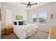 Bedroom with neutral carpet and walls, with two sunny windows and ceiling fan at 8621 S De Gaulle Ct, Aurora, CO 80016
