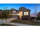 Charming two-story home with a well-lit entrance, stone accents, and manicured lawn at 8621 S De Gaulle Ct, Aurora, CO 80016
