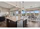 Open-concept kitchen featuring a granite island, stainless steel appliances, and an eat-in area with dining table at 8621 S De Gaulle Ct, Aurora, CO 80016