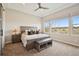Serene main bedroom featuring a tray ceiling, neutral colors, and large windows offering natural light and views at 8621 S De Gaulle Ct, Aurora, CO 80016