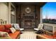 Cozy covered porch with a stone fireplace, comfortable seating, and scenic views at 8621 S De Gaulle Ct, Aurora, CO 80016