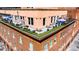 Aerial view of a building with a rooftop deck featuring seating, greenery, and city views at 1501 Wazee St # 4B, Denver, CO 80202