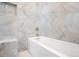 Sleek bathroom features a modern soaking tub and a wall tiled in elegant marble at 1501 Wazee St # 4B, Denver, CO 80202