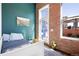 Bedroom with colorful walls, a white daybed, exposed brick accents, and city views at 1501 Wazee St # 4B, Denver, CO 80202