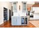 Chic kitchen featuring custom cabinets, beverage fridge, marble backsplash, and hardwood floors at 1501 Wazee St # 4B, Denver, CO 80202