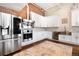 Modern kitchen equipped with stainless steel appliances, custom cabinets, and wooden floors at 1501 Wazee St # 4B, Denver, CO 80202