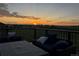 Inviting covered deck with plush seating, offering sunset views and an outdoor living experience at 19429 E 65Th Pl, Aurora, CO 80019