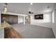 Large living room with modern ceiling fan, wood accent wall, wet bar, and access to the staircase at 19429 E 65Th Pl, Aurora, CO 80019