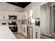 Modern kitchen with stainless steel appliances, white cabinets, and sleek black hardware at 7918 Raleigh Pl, Westminster, CO 80030