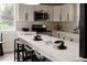 Modern kitchen boasts white countertops and cabinetry, stainless steel appliances, and barstool seating at 7918 Raleigh Pl, Westminster, CO 80030