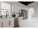 Modern white kitchen featuring stainless steel appliances, white cabinets, and a black ceiling at 7918 Raleigh Pl, Westminster, CO 80030