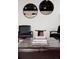 Chic seating area with black leather chairs and stylish ottoman; accentuated by modern round mirrors at 7918 Raleigh Pl, Westminster, CO 80030