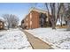 Well-maintained brick apartment building with tidy landscaping and snow-covered grounds at 5995 W Hampden Ave # 13G, Denver, CO 80227