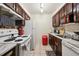A cozy kitchen area featuring white appliances, cabinetry, and tiled flooring at 5995 W Hampden Ave # 13G, Denver, CO 80227