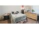 This bedroom has a soft light green blanket on the bed and a dresser against the wall at 5995 W Hampden Ave # 13G, Denver, CO 80227