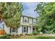 Two-story home featuring white brick, black shutters, a well-kept green lawn, and mature landscaping at 16051 E Alabama Dr, Aurora, CO 80017