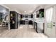 Modern kitchen with black cabinets, stainless steel appliances, and light-colored flooring at 16051 E Alabama Dr, Aurora, CO 80017