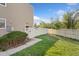 View of fenced backyard with small lawn area and view of the exterior wall of the property at 9675 E Kansas Cir # 45, Denver, CO 80247