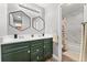 Modern bathroom with double sinks, dark green vanity, hexagon mirrors and shower/tub combo at 9675 E Kansas Cir # 45, Denver, CO 80247
